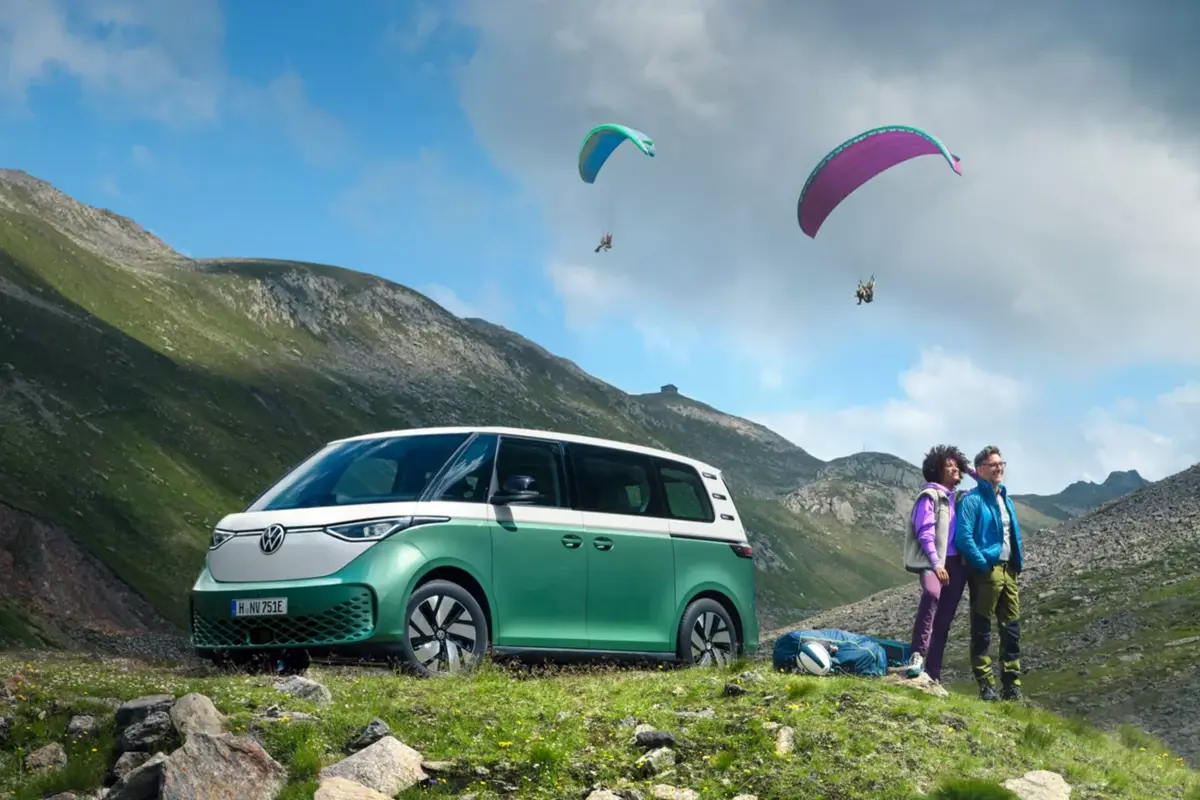 zwei Personen gehen wandern, dahinter steht ein grüner ID Buzz