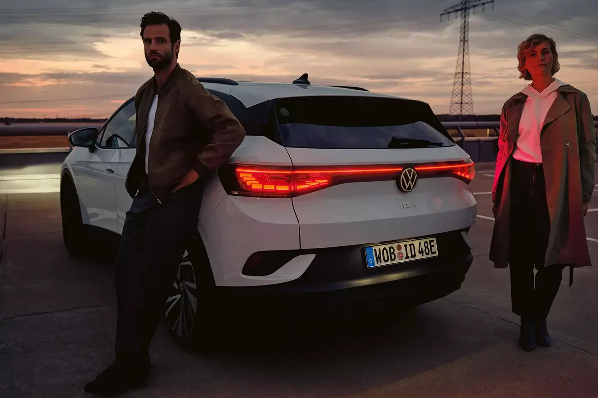 ID 4 bei Nacht von hinten, ein Paar lehnt am Auto