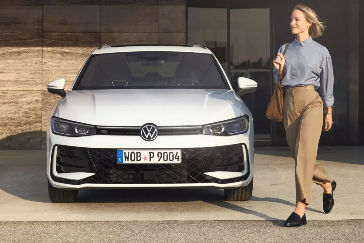 weißer VW Passat, daneben eine geht eine Frau 