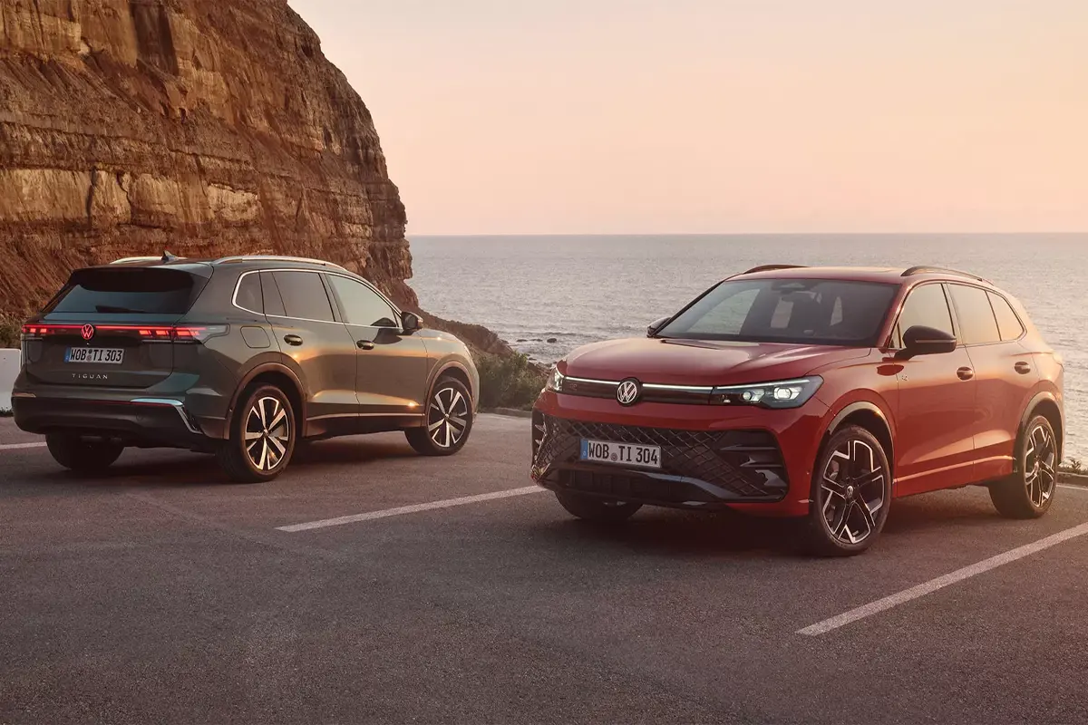 zwei Tiguan am Parkplatz, ein grauer und ein roter Tiguan.